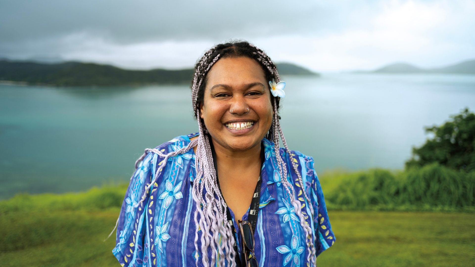 Women with purple braids smiles at camera