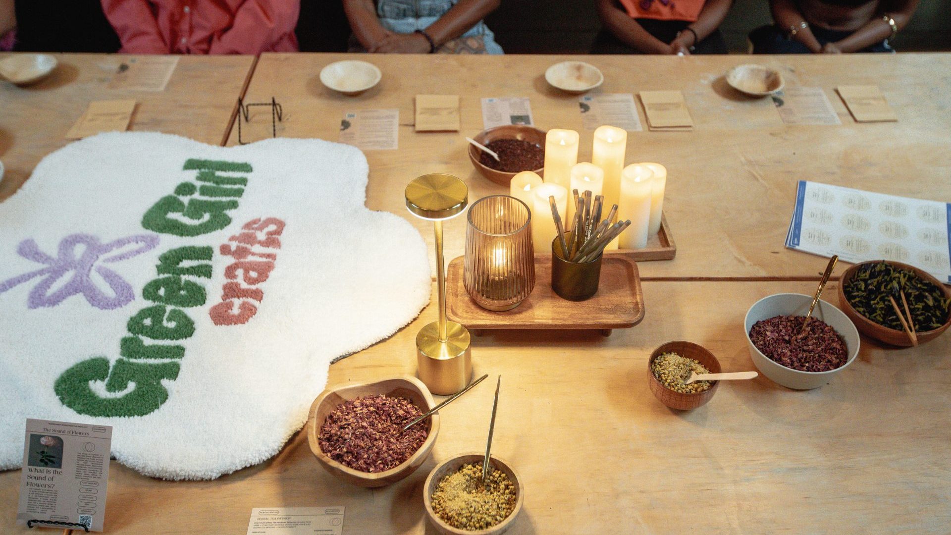 Table with sign reading 'green girl crafts' and topped with craft paraphernalia