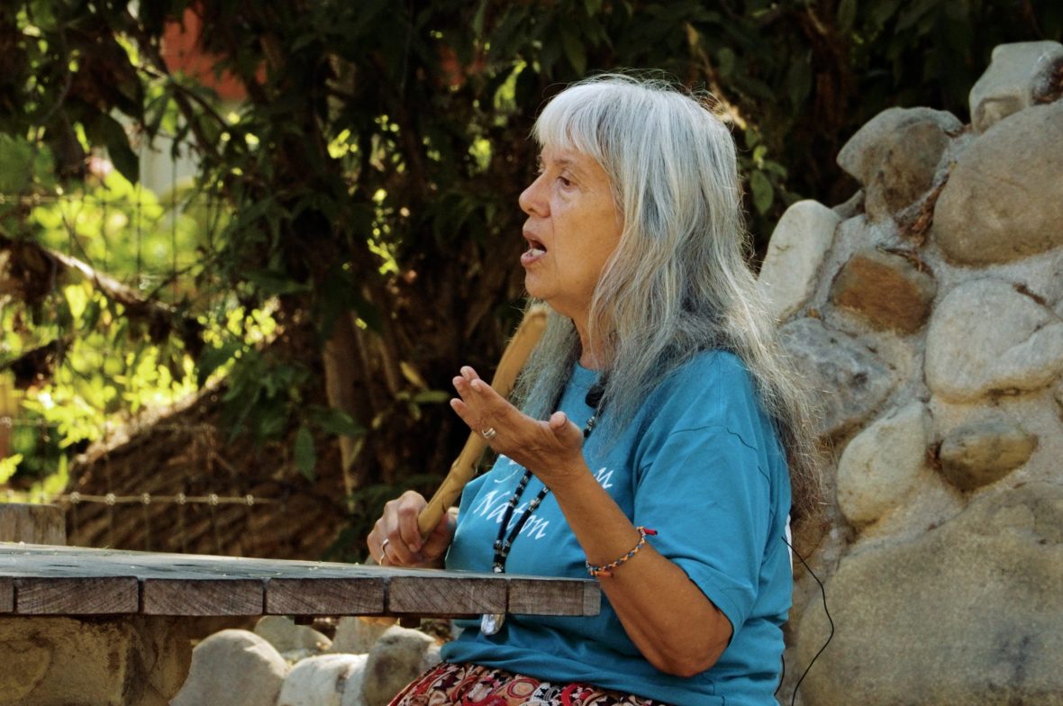 Indigenous woman plays elderberry clapstick