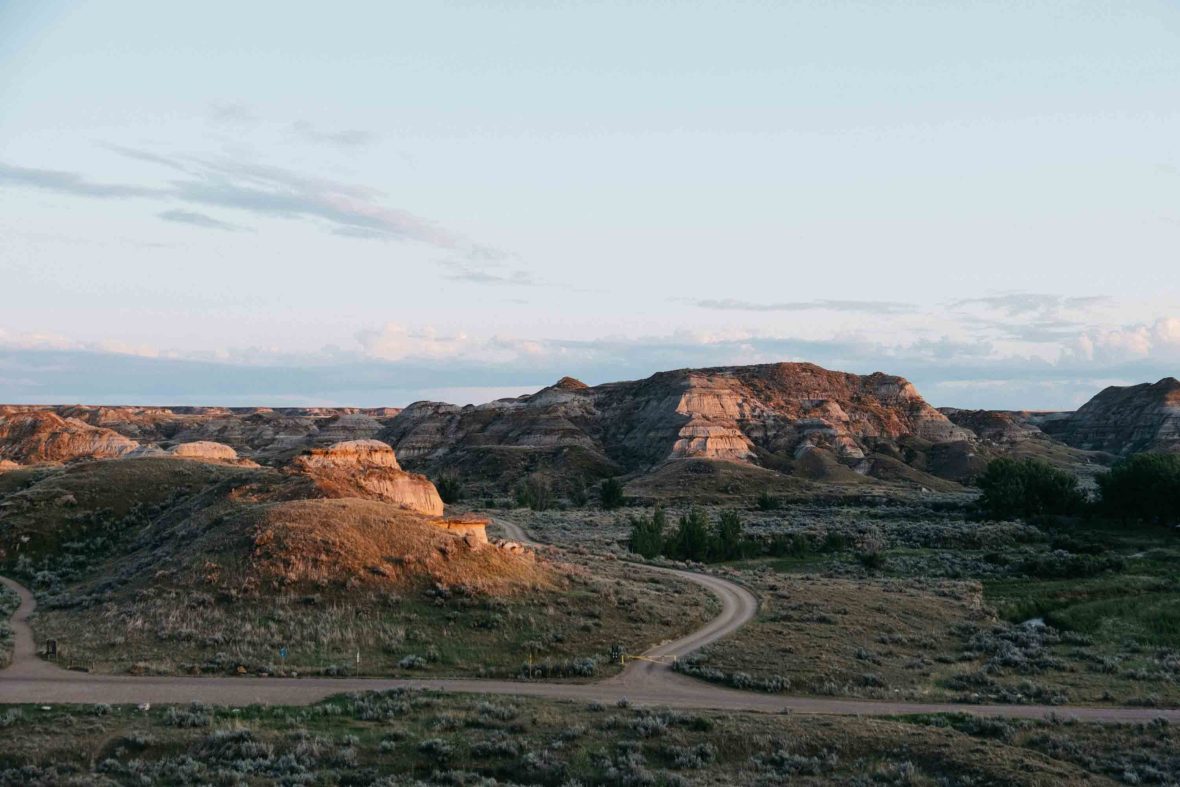 A road leads to some rocky hills.