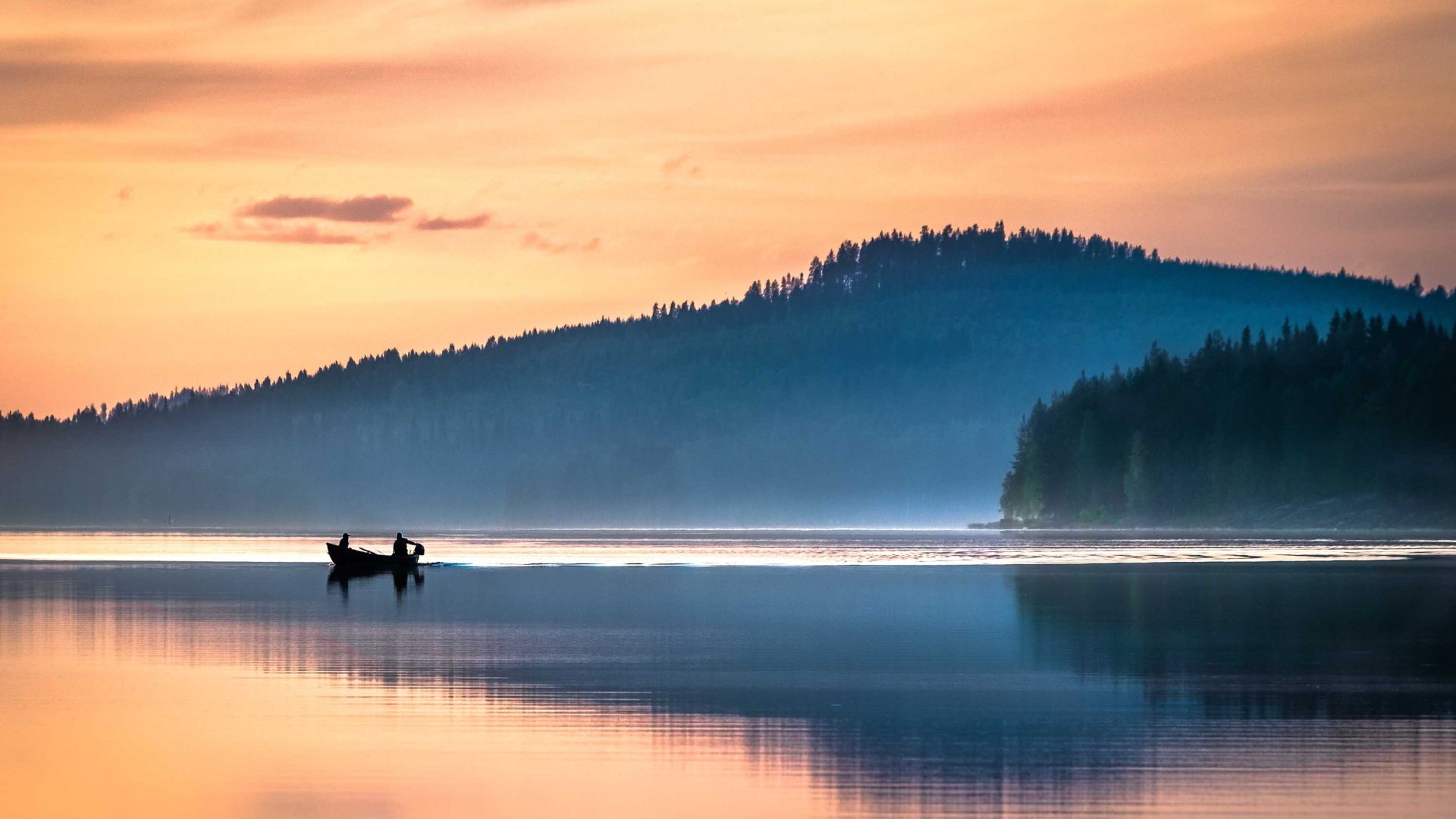 A person in a canoe as the sun sets.