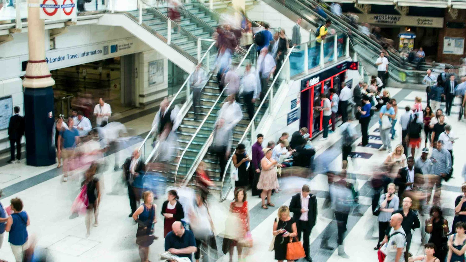 People are blurred as they move through a crowded tube station in London.