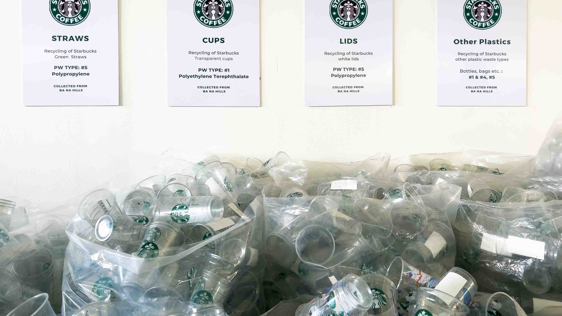 A pile of plastic cups and lids with signs indicating what they are.
