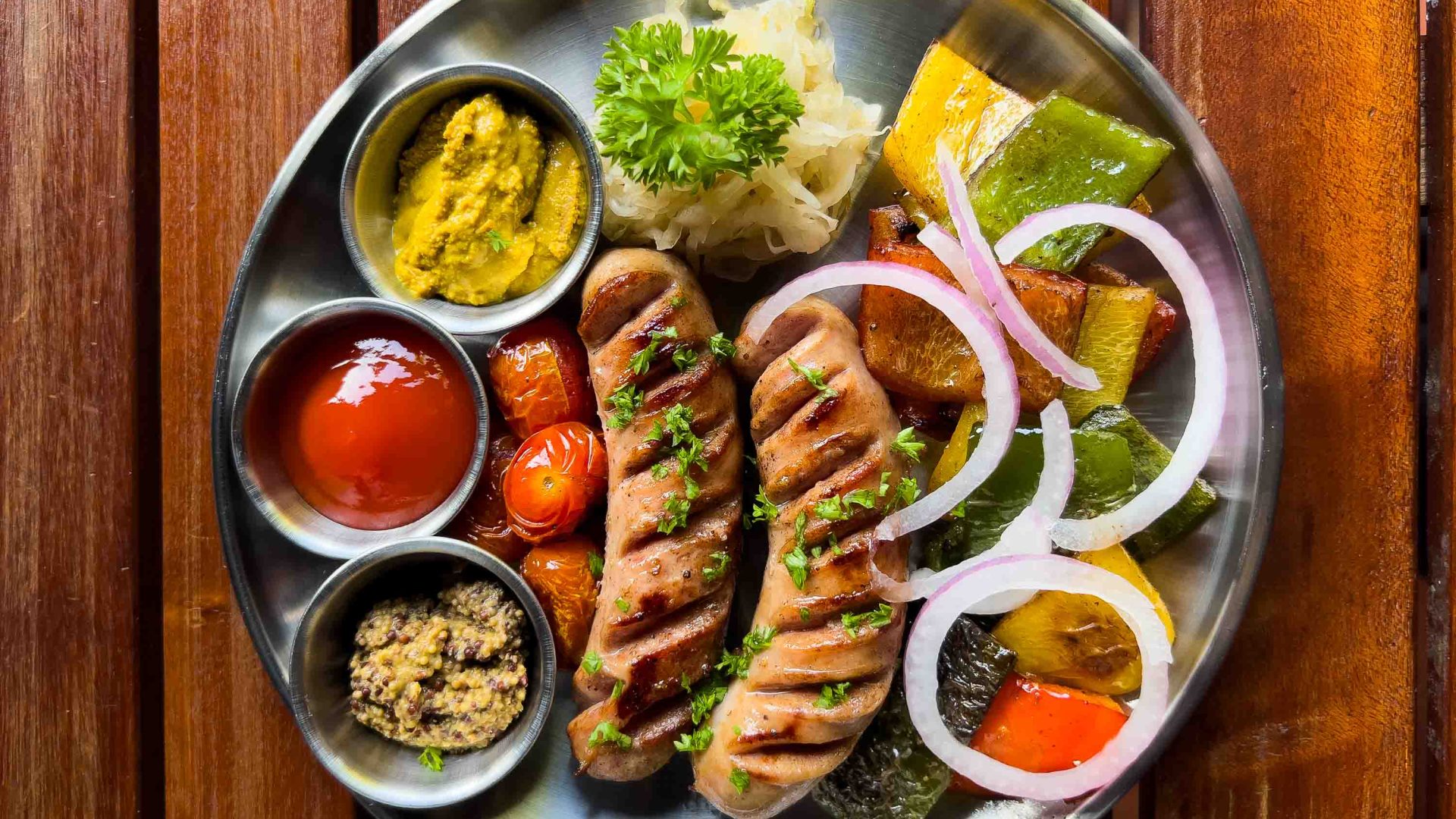 Hot dogs and an assortment of condiments and salad.