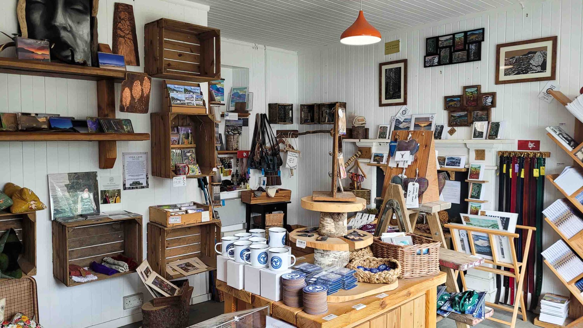 The interior of a craft shop selling a range of items from mugs and coasters to leather belts and knitted bags.