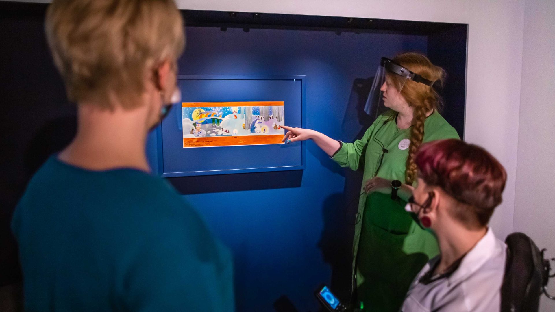 Moomins art is shown on a wall at the museum.