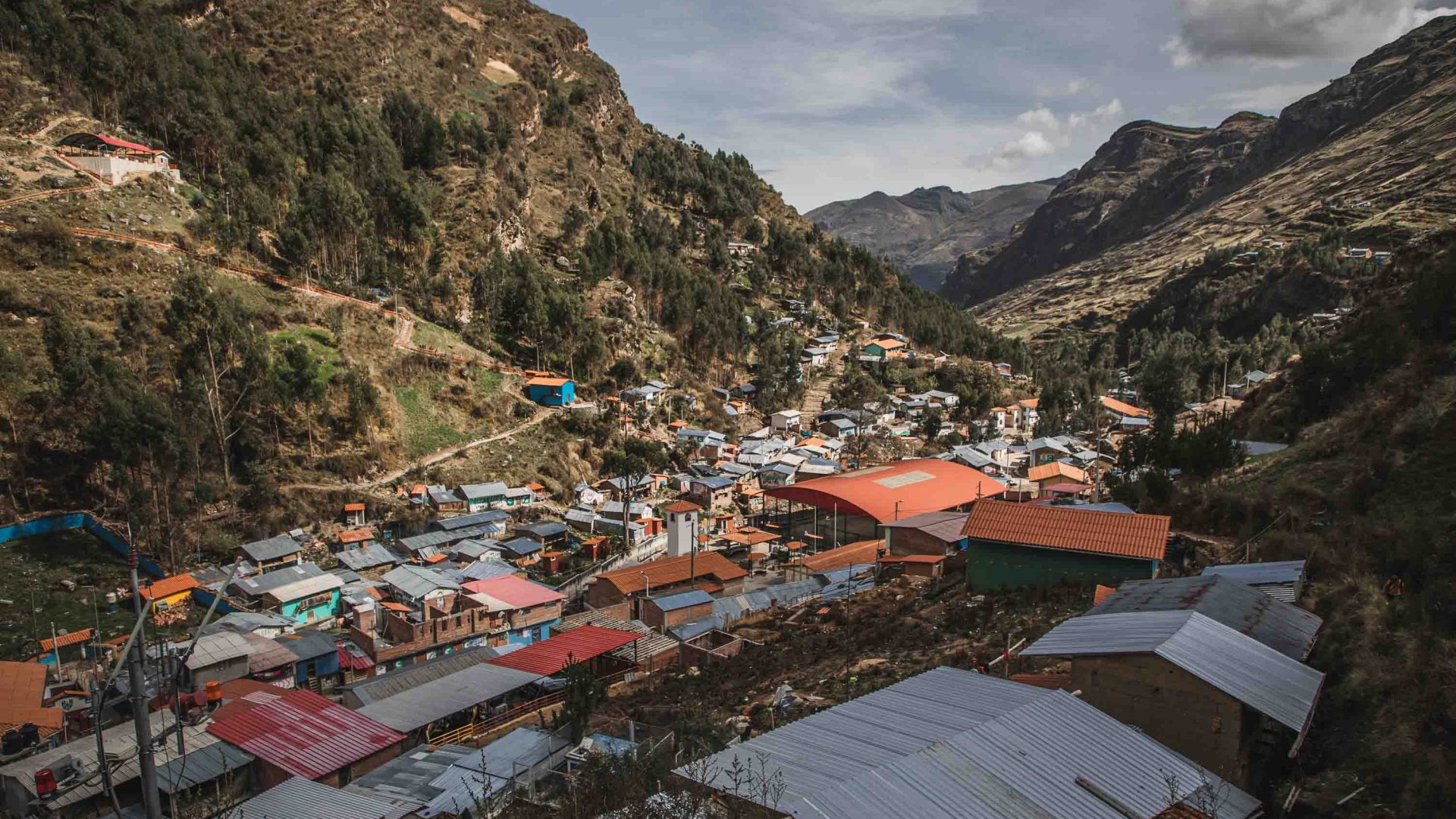 Houses with red roofs line a valley.