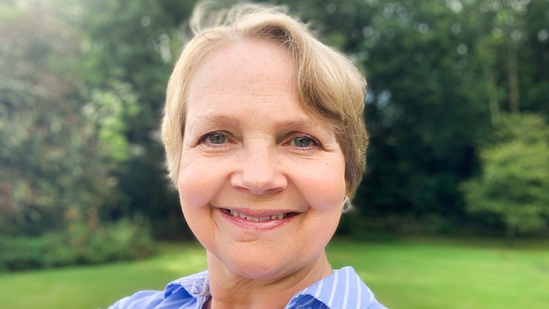 A woman smiles to camera in a selfie.