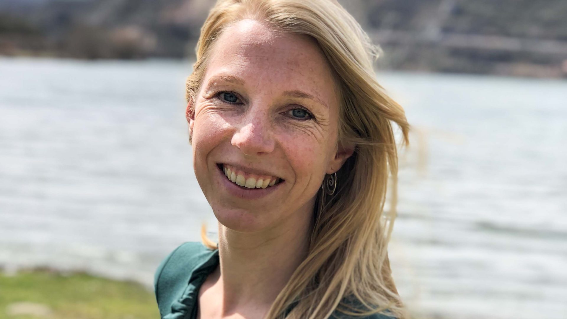 A woman with blonde hair smiles to camera.