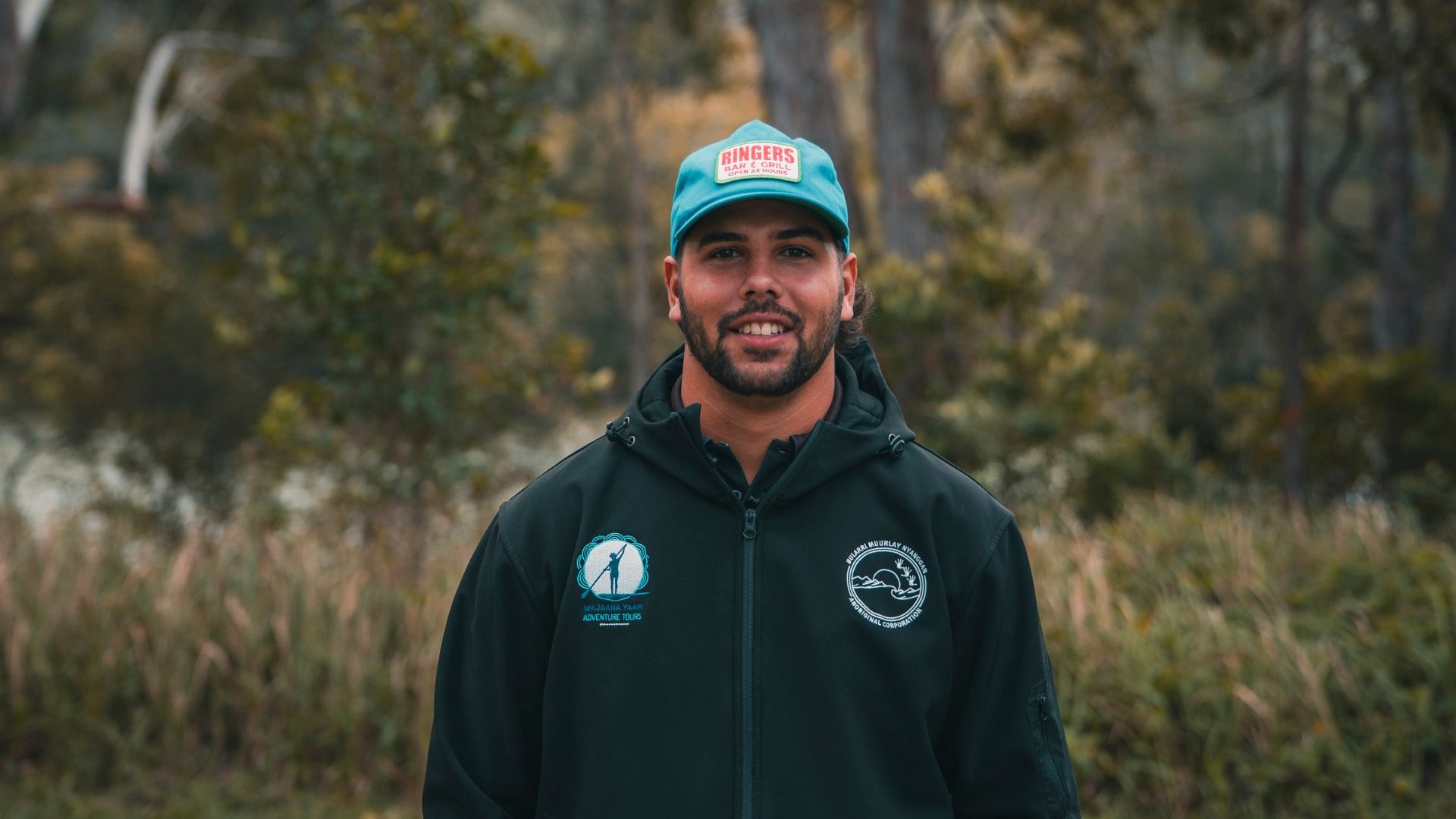 Man wearing blue hat smiles at camera