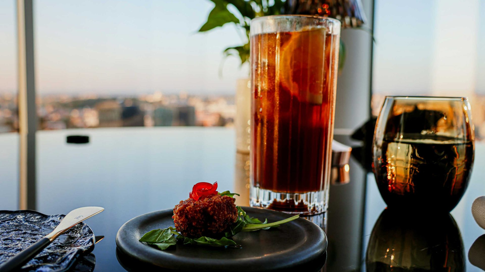 A small plate of food and a cocktail.